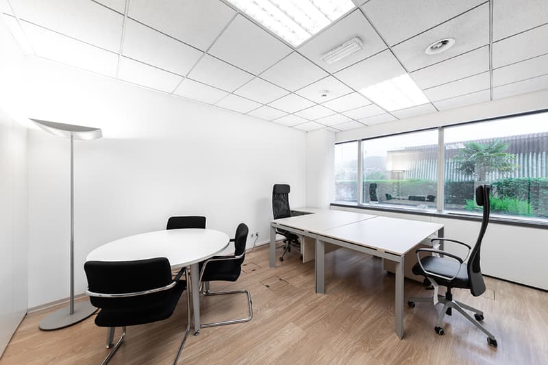 modern meeting room, white walls, wooden floor, white desks, black office chairs, modern lamps