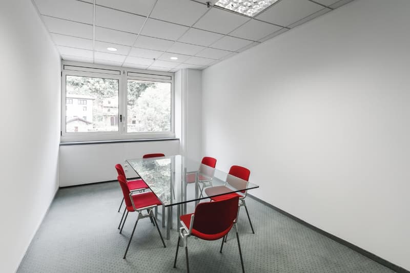 glass desk, 6 red chairs, window overlooking outside