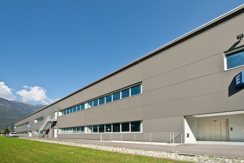 modern industrial building, grey exterior, many windows, stairs, double door entrance