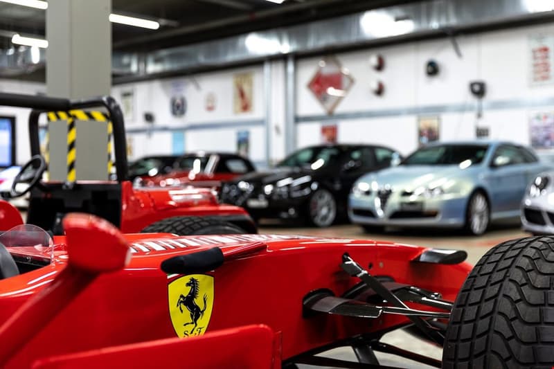 Car storage, several luxury cars, including a red Ferrari, silver Audi, black vehicle, red buggy, red car front visible