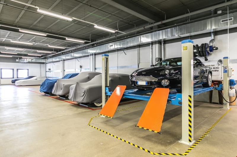 Industrial sized garage with covered cars and car lifting equipment