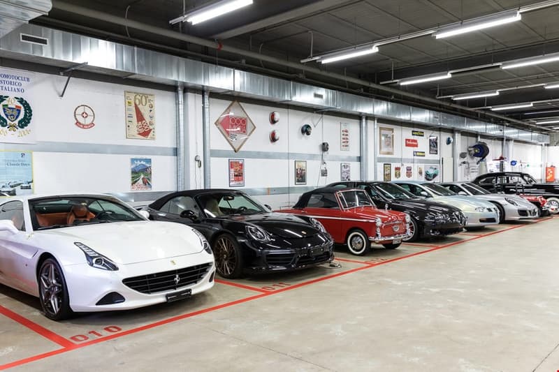 Underground garage, rows of luxury cars, signs on wall, illuminated ceiling