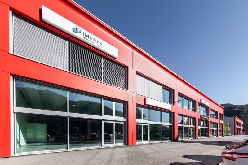 red building, glass windows, parked car