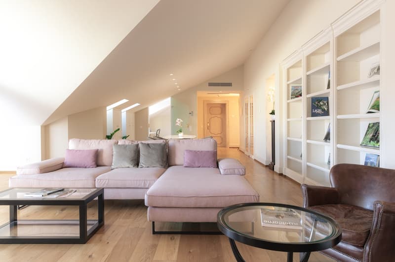 modern living room with wood floor, corner sofa, wooden coffee tables, bookshelves, light fixtures