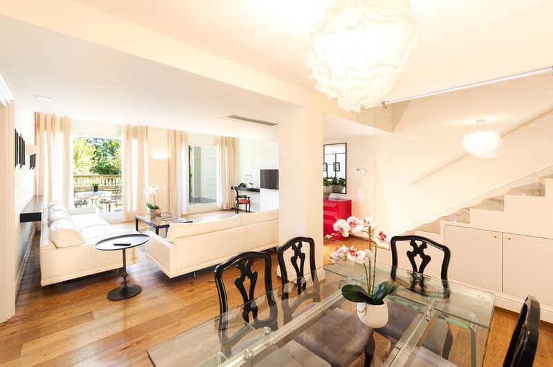glass coffee table, leather chairs, white couches, balcony, modern chandelier, plants, stairs