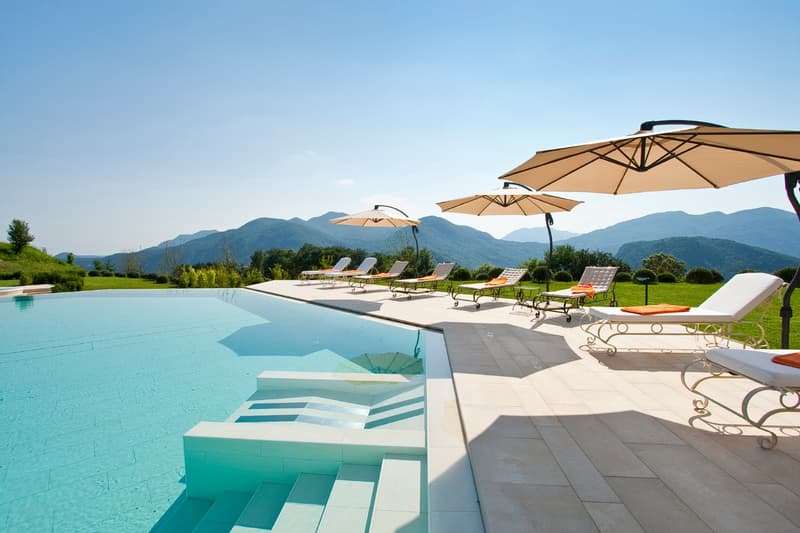 outdoor pool, lounge chairs, parasols, tile flooring, steps into pool