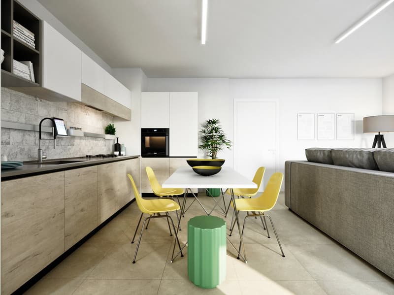 The image shows a modern, open-concept kitchen and dining area. The kitchen features white cabinets, a marble backsplash, and a black oven. The dining area has a white table with yellow chairs, and a green stool. There is also a potted plant and some artw