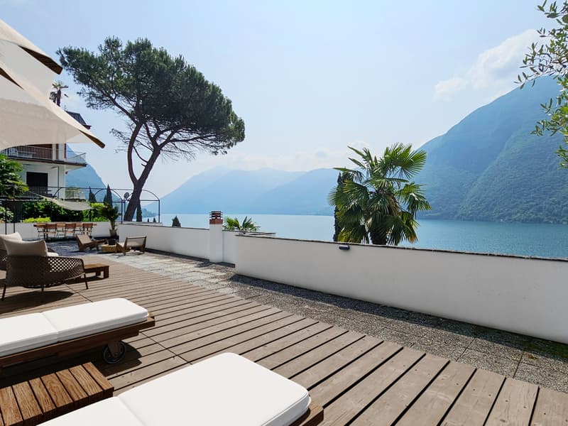 deck with outdoor furniture, trees, panoramic view of the lake and mountains