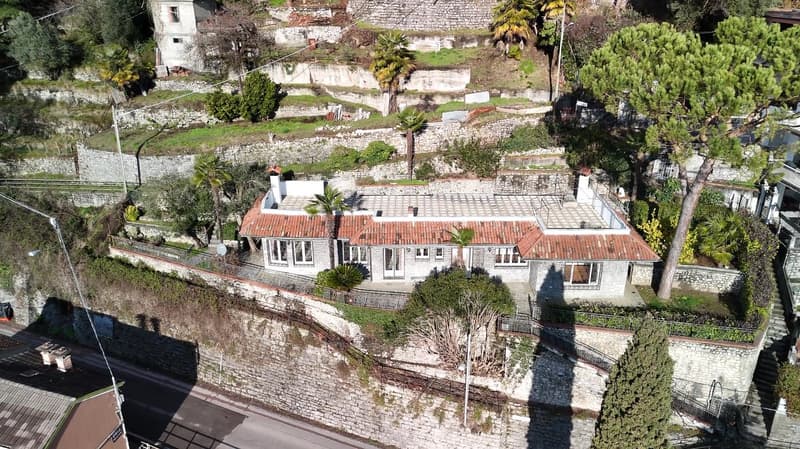 Terraced house, stone walls, red roof, chimneys, multiple windows, front yard, terrace