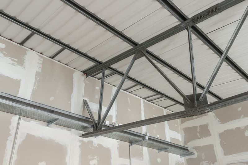 Exposed metal beams, unfinished walls, metal shelves, unfinished ceiling