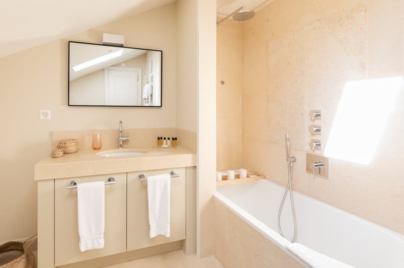 Bathroom with a bathtub, sink, mirror, and towel rack