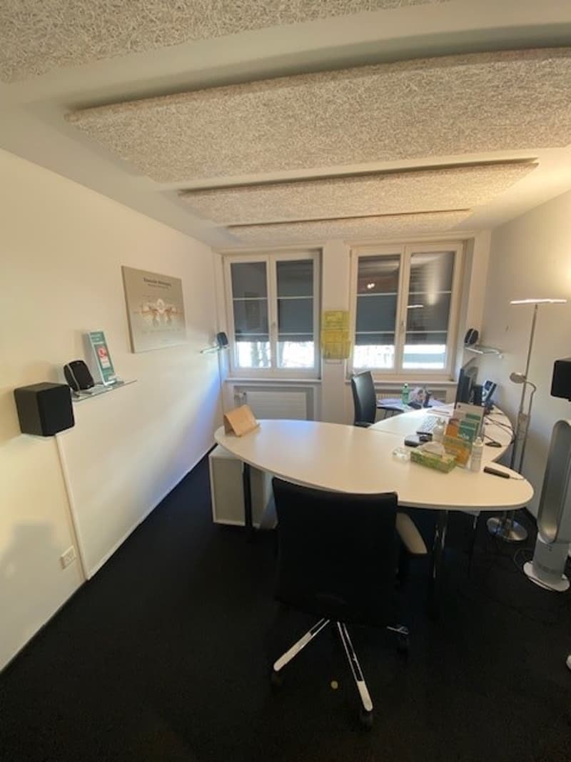 empty office, large desk, black chairs, white walls, white table, windows