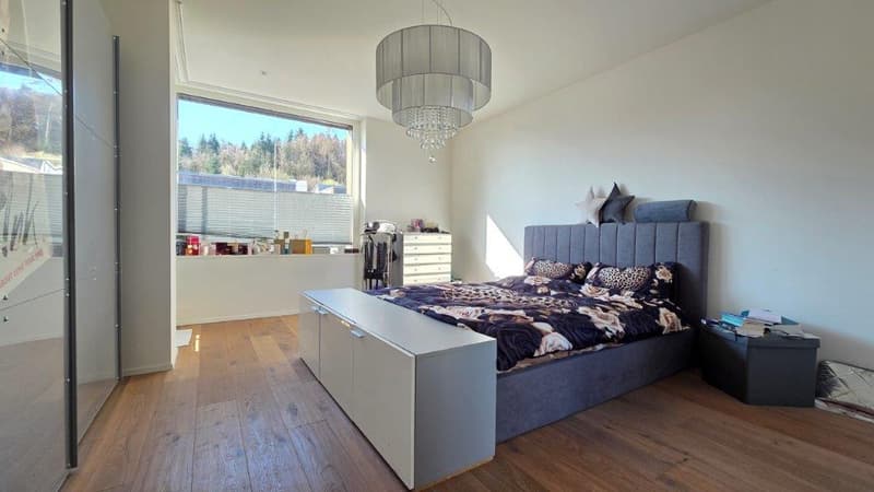 large bed, white headboard, wooden floor, large window, chandelier, nightstands, wardrobe