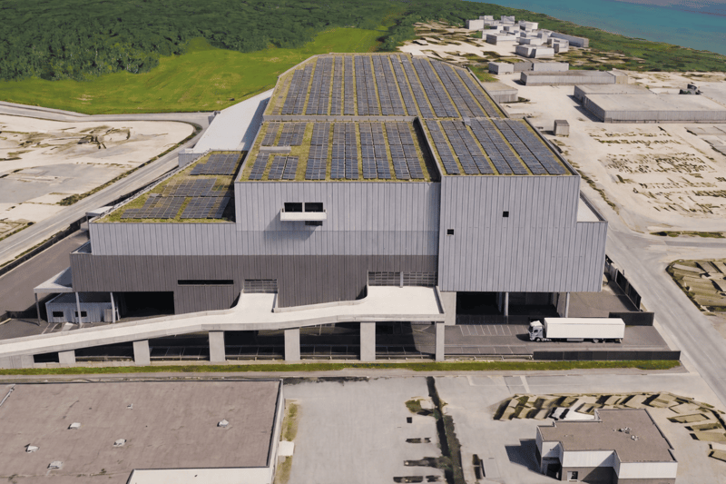 solar panels on roof, elevated building, road in front, truck present
