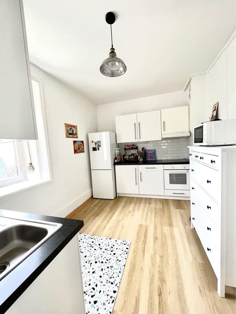 fully-equipped kitchen with wooden floor, stainless steel sink, white cabinets, white refrigerator, microwave, stove, and oven