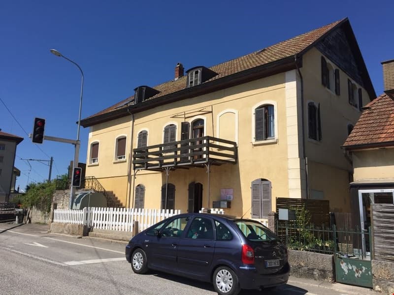 3 story house, yellow exterior, balcony, white fence, parked car