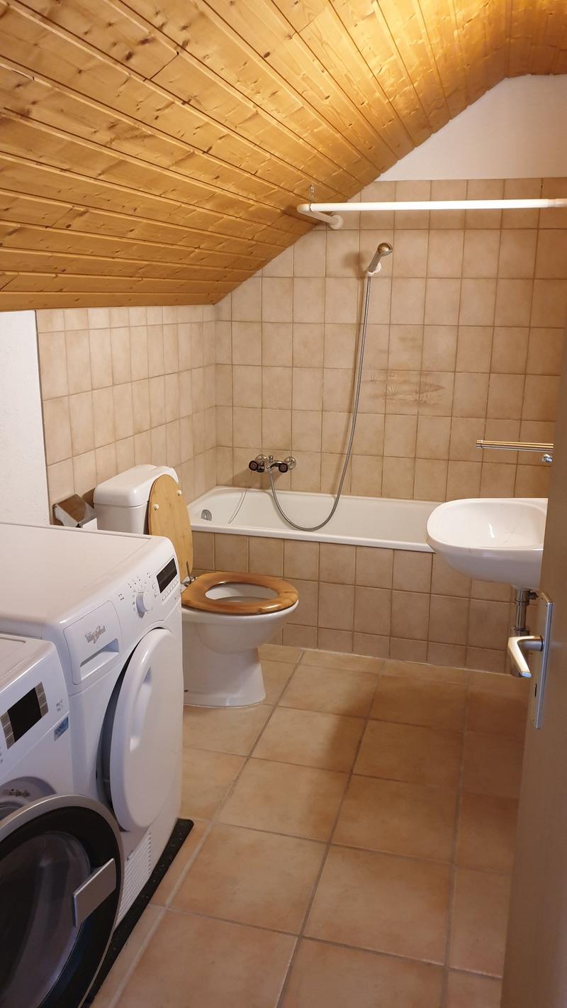 Bathroom with bathtub, toilet, sink, washing machine, and dishwasher.