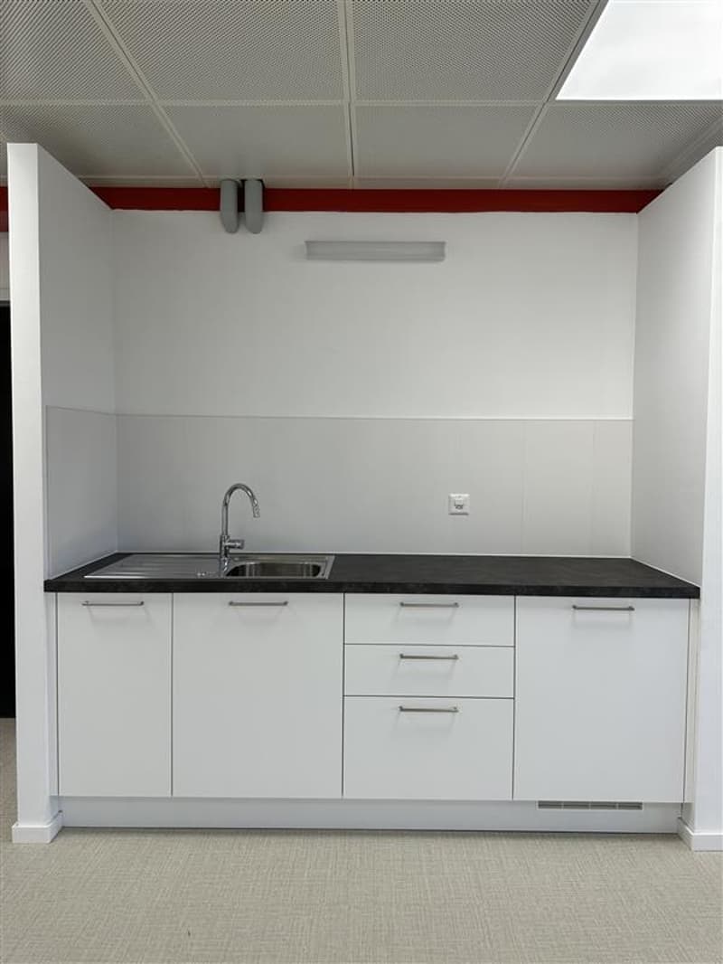a compact kitchen with a single stainless steel sink and three cabinets
