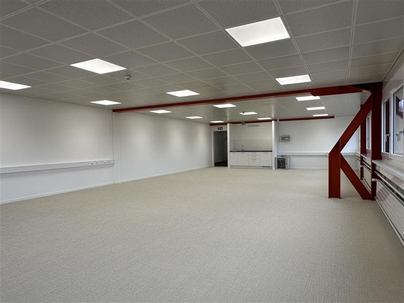 Empty room, white walls, suspended ceiling, red support beams, square ceiling lights