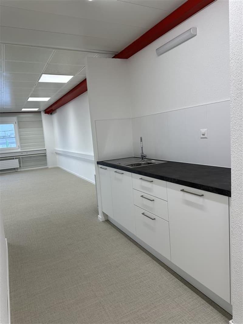 empty room, with white tiled floor, white walls, a kitchen counter, sink, cabinets and a ceiling lamp
