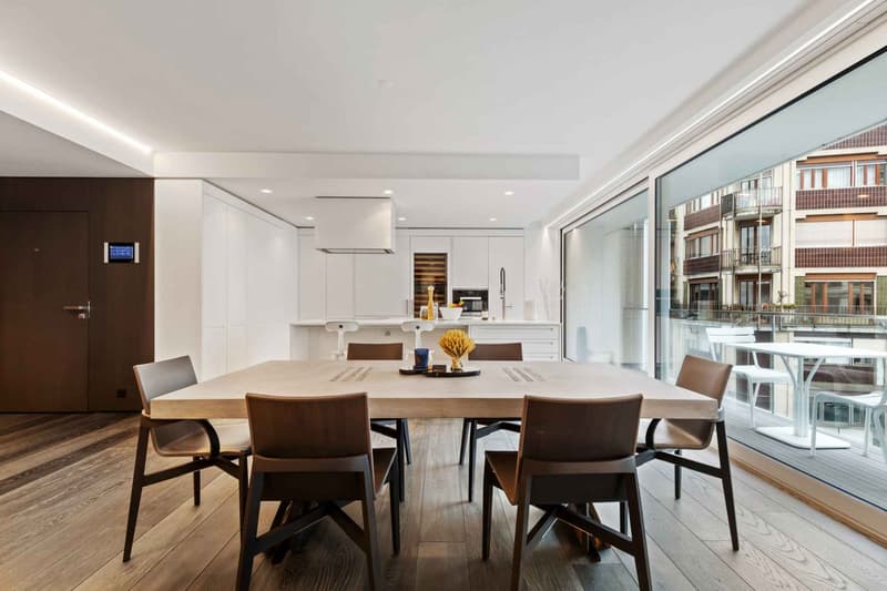 Salle à manger ouverte sur la cuisine et accès à la terrasse
