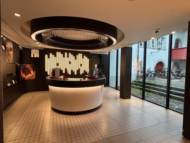 counter with coffee machines, circular ceiling light, large windows, bicycles parked outside