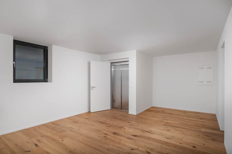 empty room, wooden floor, white walls, open door, elevator shaft