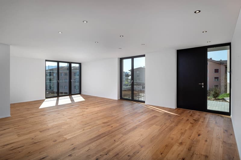 empty room, hardwood floors, white walls, large windows, sliding glass doors leading to balcony
