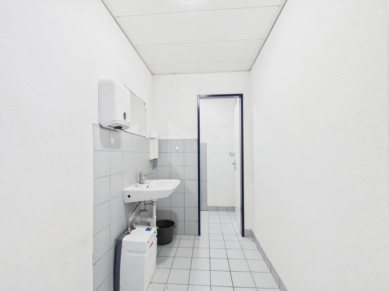 white tiled floor, sink, water dispenser, trash bin, bathroom door
