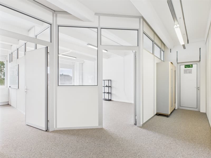 empty room with white walls and glass doors, carpeted floor, windows, office shelves