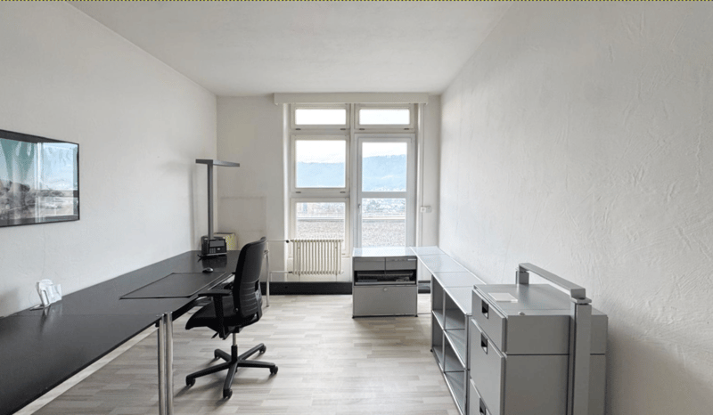 spacious room with two desks, black office chair, printer, filing cabinet, glass doors and windows, picture frame