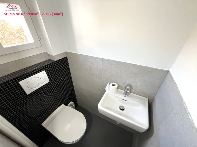 Toilet, sink, wall-mounted soap dispenser, shower curtain, tiles, countertop, water tap