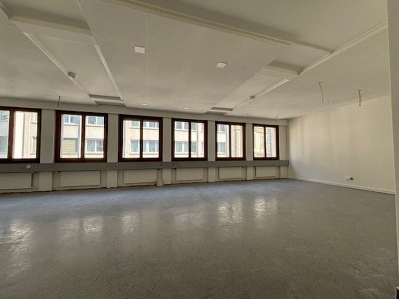 empty office room, white walls, large windows, gray floors, white ceiling