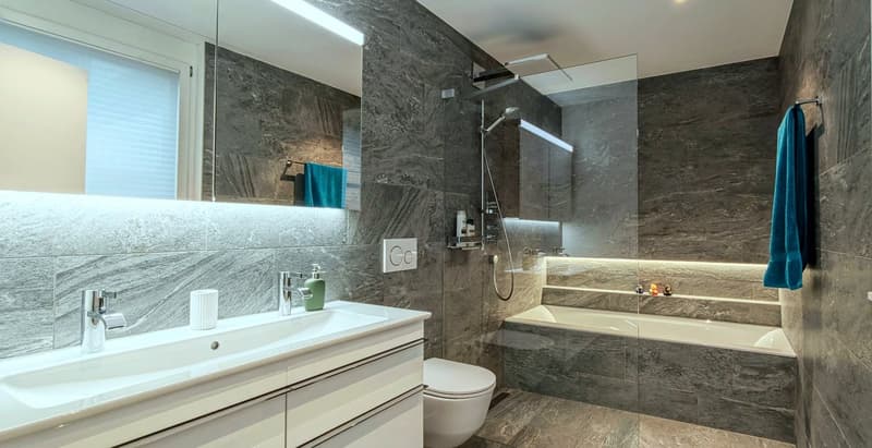 modern marble bathroom with shower, bathtub, sink, and toilet