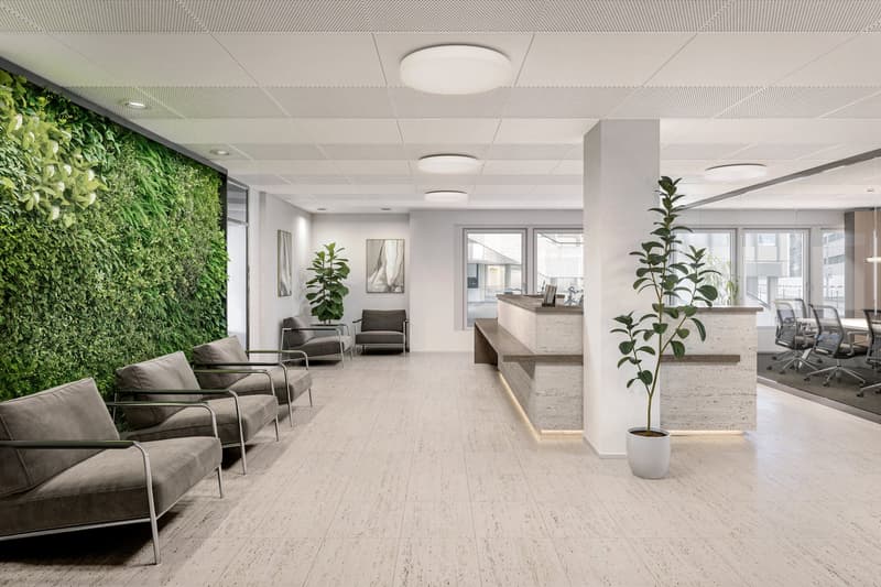 Waiting area with couch, plant, reception desk, wall with plants