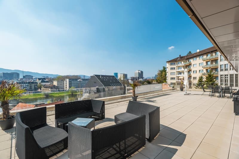 outdoor furniture, potted plants, glass railing, view of the city