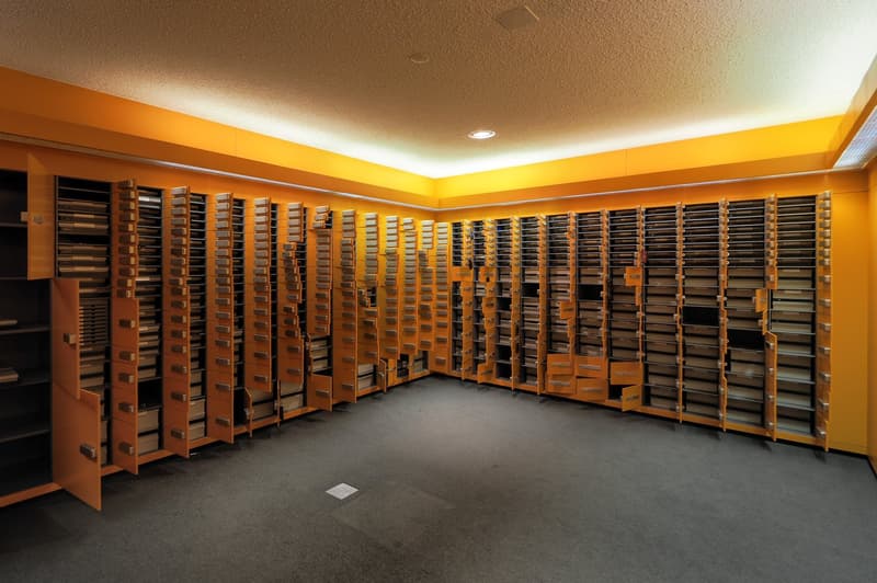 large room with multiple drawers, yellow wall, ceiling lamp