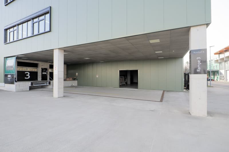 Concrete parking garage with multiple ramps, labeled ramps 3 and 8, and two open garages with signage and loading ramps