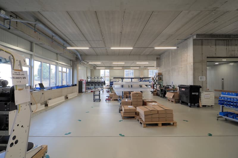 large empty warehouse, fluorescent lighting, stacked boxes, office equipment