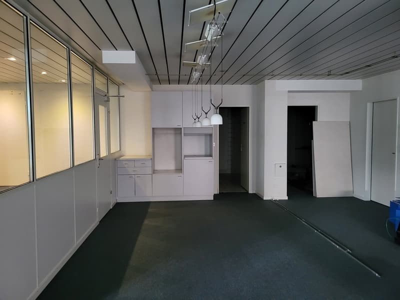 Modern office room, clean white walls, white ceilings, large windows, built-in cabinets, hanging pendant lights