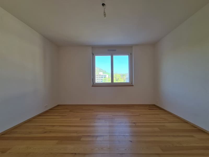 empty room with hardwood floor, white walls, window