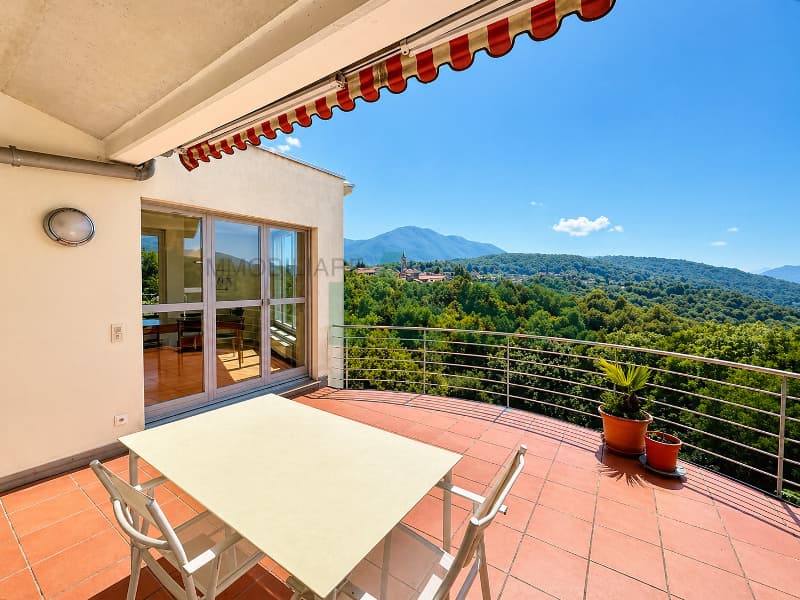 un balcone con sedie e vista sulle montagne / a balcony with chairs and a view of the mountains
