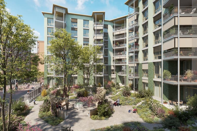 Multi-story apartment building with balconies, surrounded by lush greenery and landscaping, including trees, flowers, and a central courtyard with a fountain or water feature. The building has a modern, contemporary design with large windows and balconies