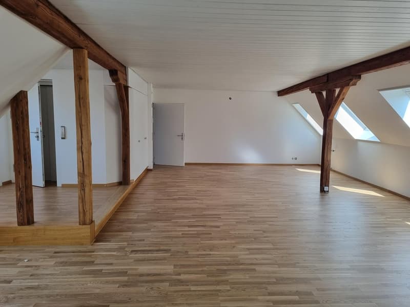 empty room, wooden beams, wooden floor, white walls, two doors, two windows
