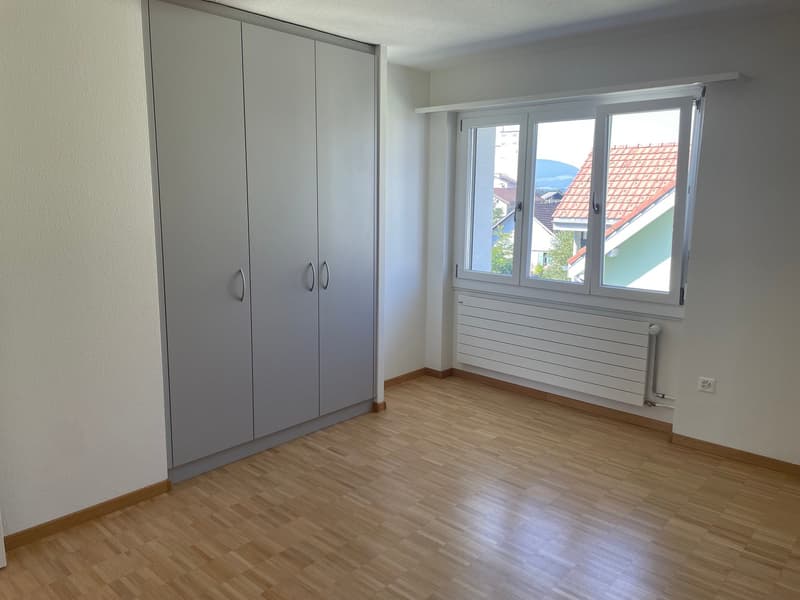 empty room, wooden floor, large window, white walls, wardrobe, radiator