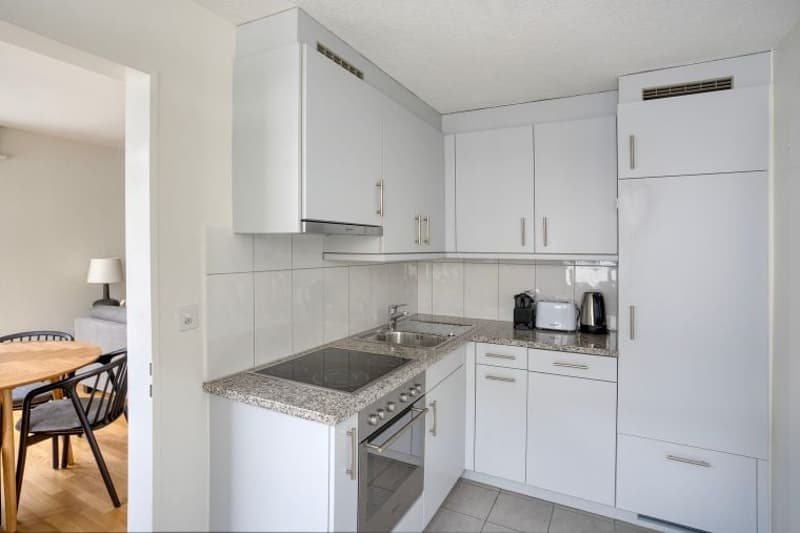 modern kitchen with white cabinets, granite countertops, electric stove, oven, sink, toaster, coffee maker, refrigerator, washing machine, dishwasher
