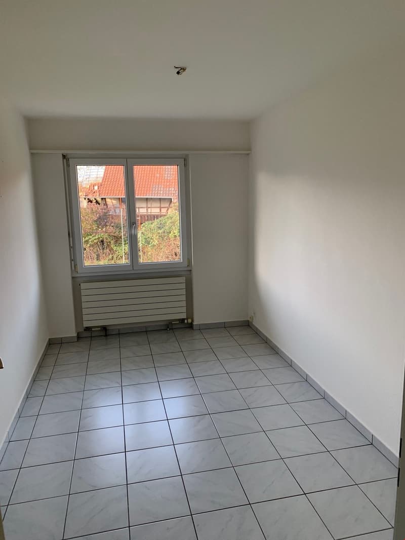 empty room with a window, tiled floor, white walls, heating element below window