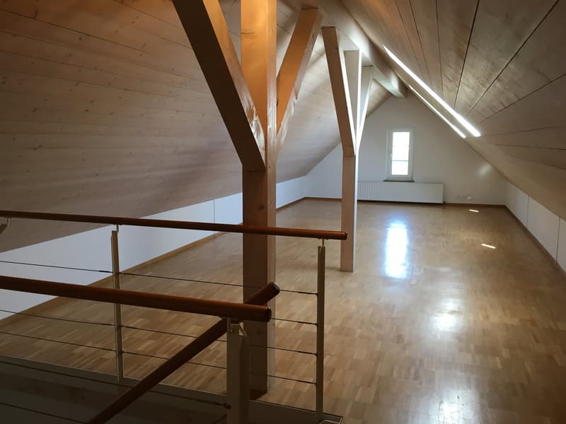 empty attic room, wooden floor, wooden beams, white walls, window, radiator