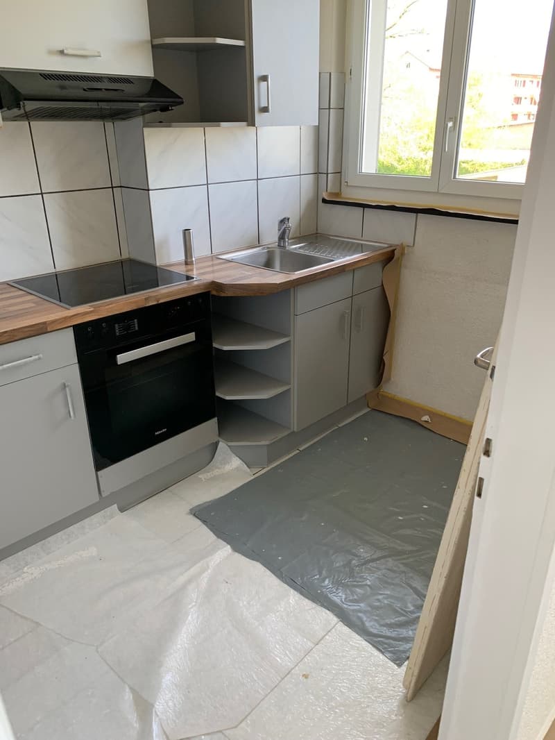 kitchen with stove, oven, sink, cabinets, and a window