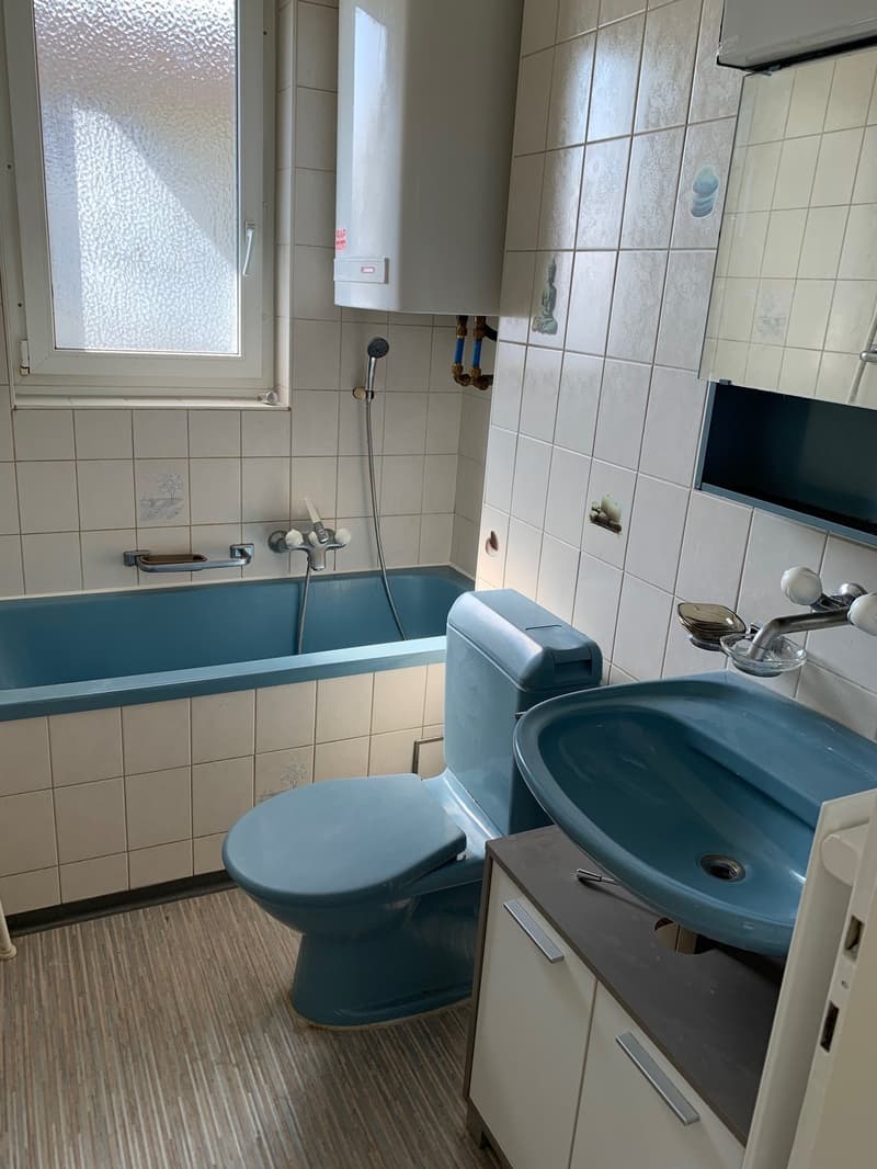 Bathroom with bathtub, toilet, sink, white tiles, wooden floor, window